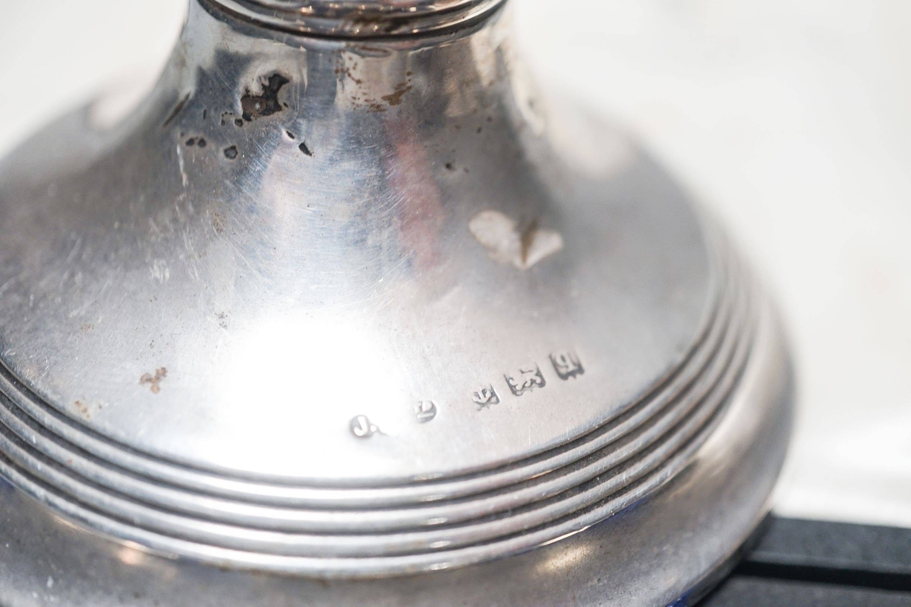 A cased set of six silver teaspoons, a cased christening set, three silver napkin rings and a silver dwarf candlestick.